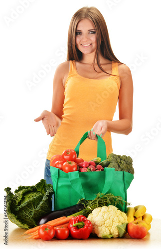 Young woman with variety of grocery products in shopping bag