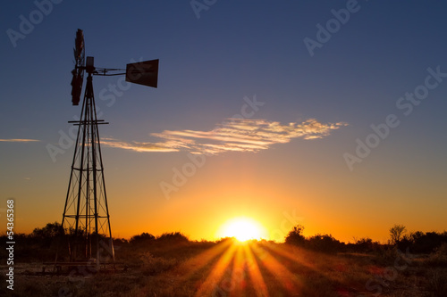 Lovely sunset in Kalahari with windmill and grass