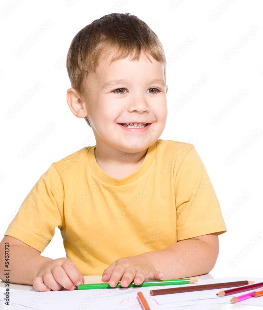 Little boy is drawing using color pencils Little boy is drawing using color pencils
