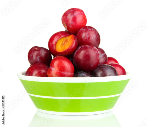 Ripe plums in bowl isolated on white