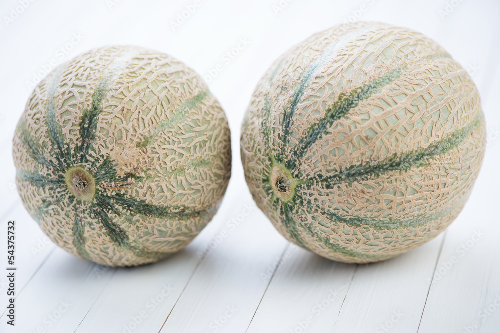 Horizontal shot of two mushmelons on wooden boards Horizontal shot of two mushmelons on wooden boards