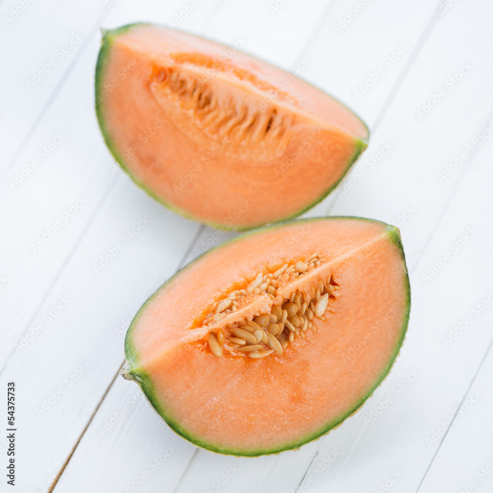 Two cantaloupe slices on wooden boards, view from above