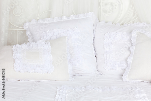 Fototapeta Naklejka Na Ścianę i Meble -  Beautiful and soft white laced pillows lie on white double bed.
