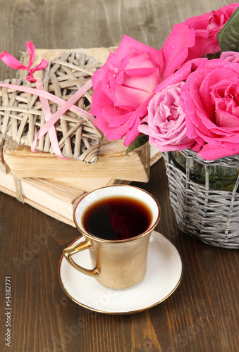 Beautiful pink roses in vase on wooden table close-up