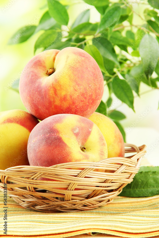 Ripe sweet peaches in basket on table, outdoors Ripe sweet peaches in basket on table, outdoors