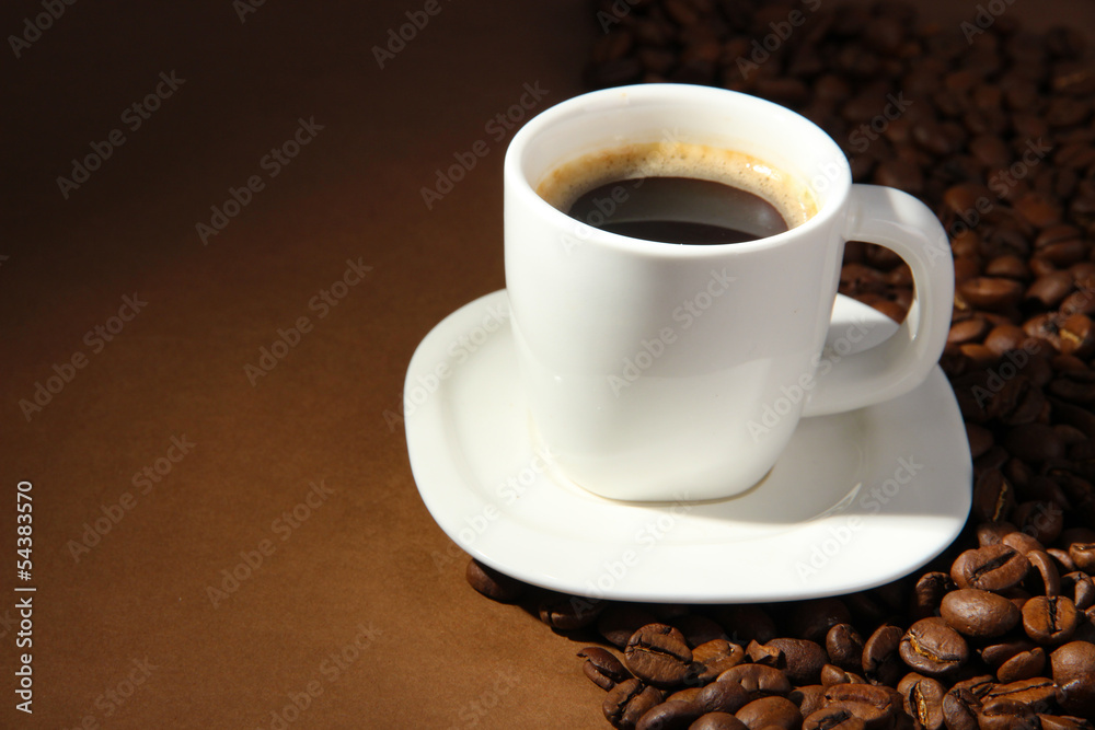 Cup of coffee with coffee beans on brown background Cup of coffee with coffee beans on brown background