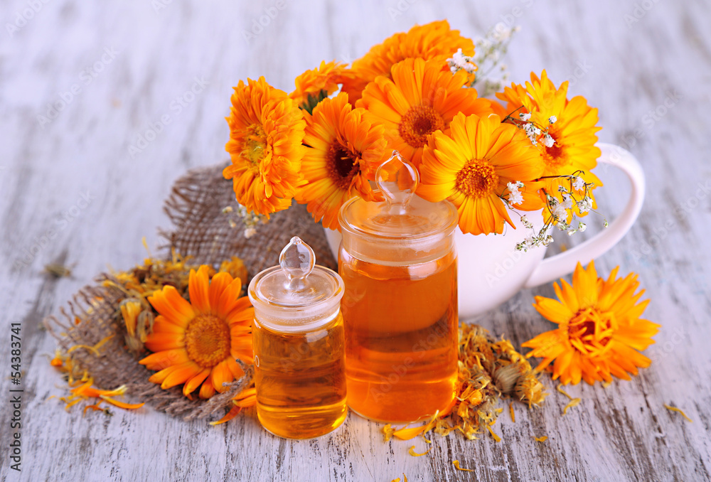 Medicine bottles and calendula flowers on wooden background Medicine bottles and calendula flowers on wooden background