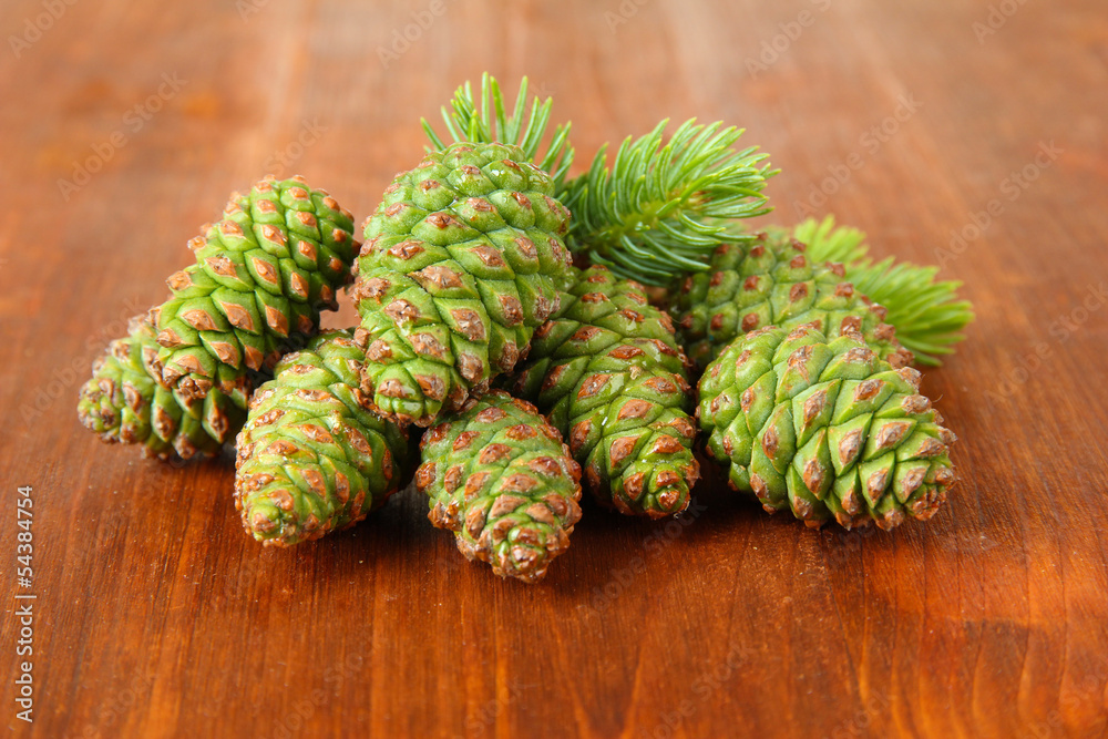 Green cones and fir tree on wooden background Green cones and fir tree on wooden background