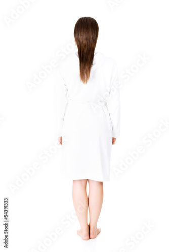 Beautiful caucasian woman in bathrobe standing back to the camer