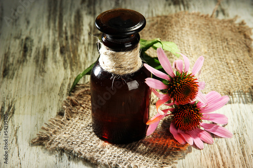 Fototapeta Naklejka Na Ścianę i Meble -  Medicine bottle with purple echinacea flowers on wooden table