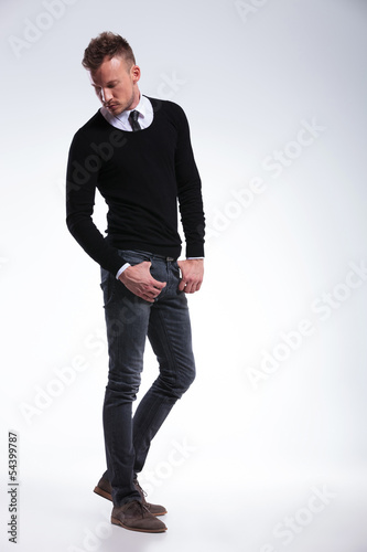 casual man looks down with thumbs in pockets