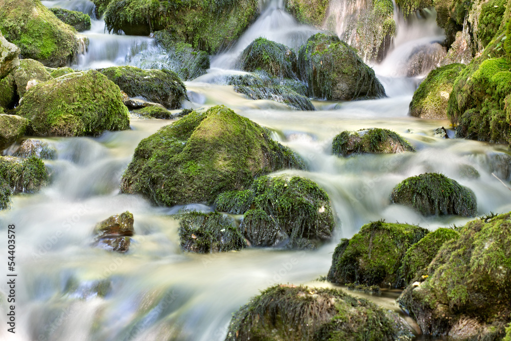 Waterfall close up in forest with stones and stream Waterfall close up in forest with stones and stream