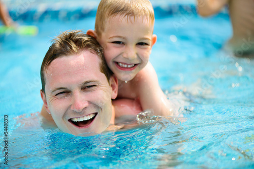 Young father and little son swimming in pool