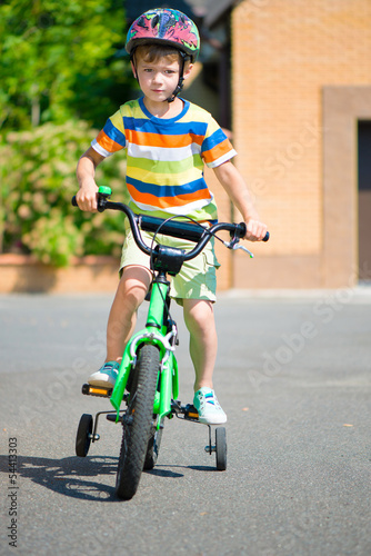 Fototapeta Naklejka Na Ścianę i Meble -  Cute little boy riding bicycle