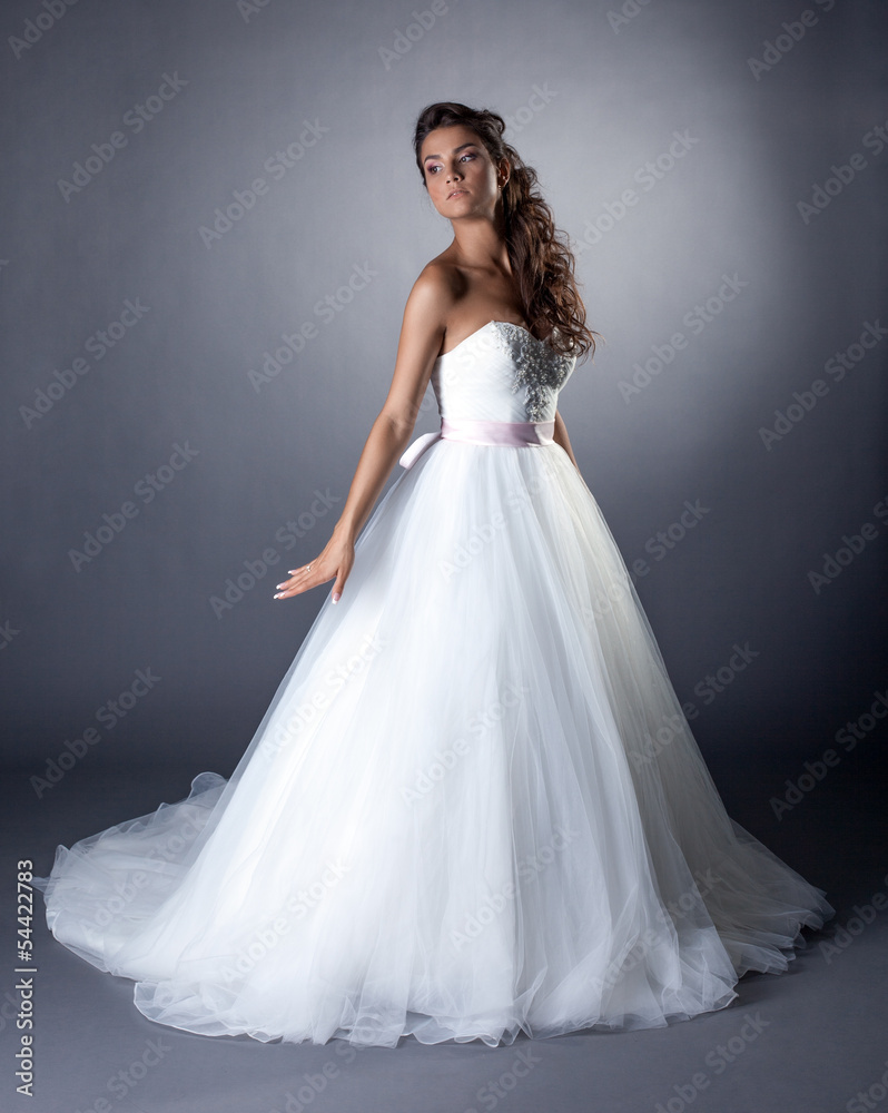 Lovely slim brunette posing in chic wedding dress Lovely slim brunette posing in chic wedding dress