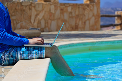 working on laptop at the pool photo