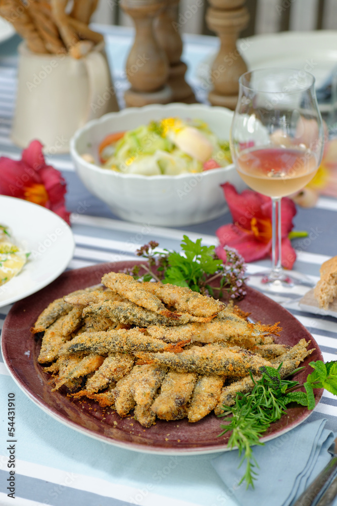 Fried sardines with potato salad, bread and  white wine