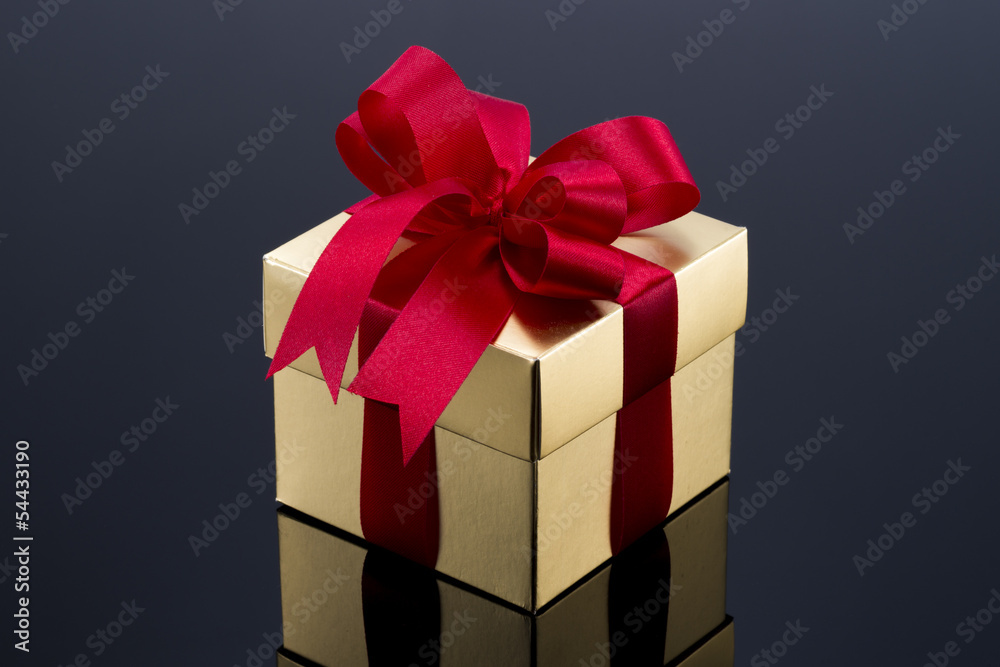Beautiful gold present box with red bow and ribbons Beautiful gold present box with red bow and ribbons