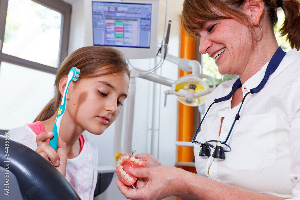 A doctor explains a young boy how they can care the teeth A doctor explains a young boy how they can care the teeth