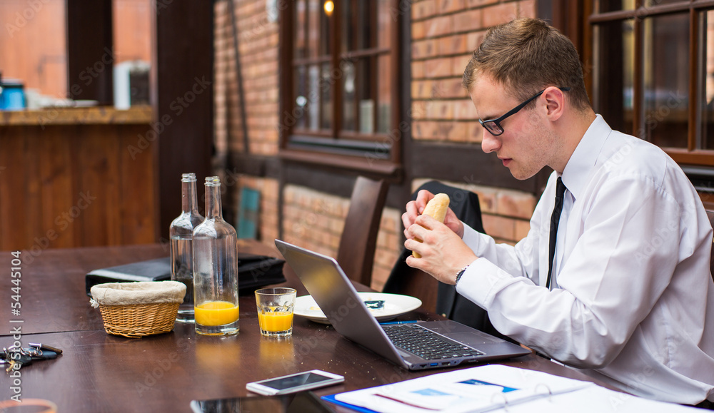 Handsome businessman work at the laptop in restaurant. Close-up. Handsome businessman work at the laptop in restaurant. Close-up.