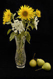 bouquet of sunflowers in a vase and pears