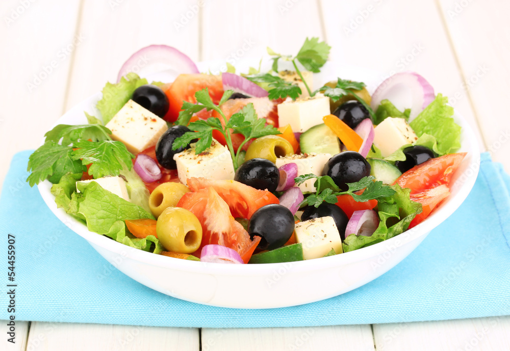 Fresh salad in plate on wooden table