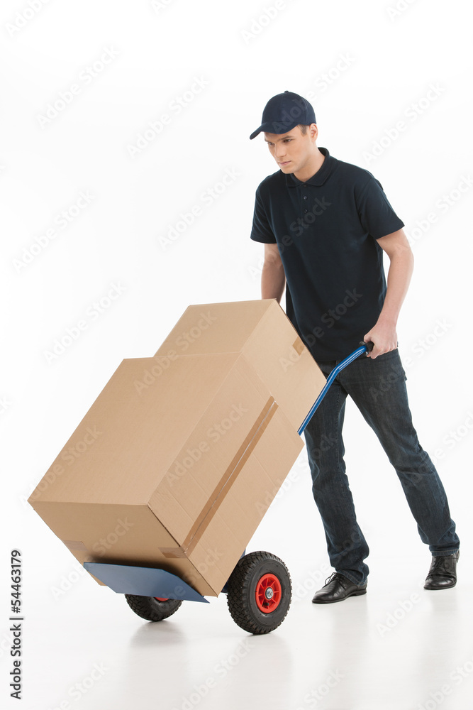 Moving house. Full length of young deliveryman with a hand truck Moving house. Full length of young deliveryman with a hand truck