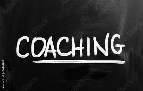 "Coaching" handwritten with chalk on a blackboard