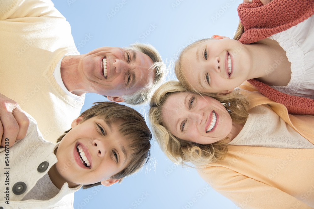 Cheerful Parents And Children Against Clear Blue Sky
