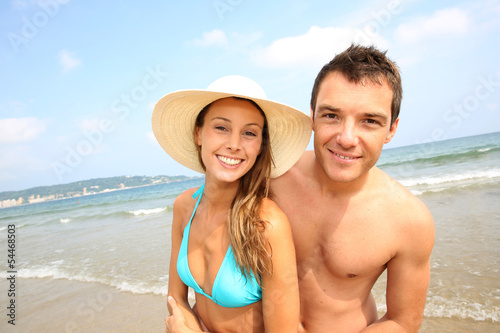 Cheerful young couple standing on the beach