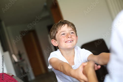 Cheerful young kid playing with daddy at home
