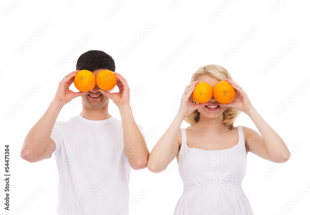 A young Caucasian couple playing wih fresh oranges A young Caucasian couple playing wih fresh oranges