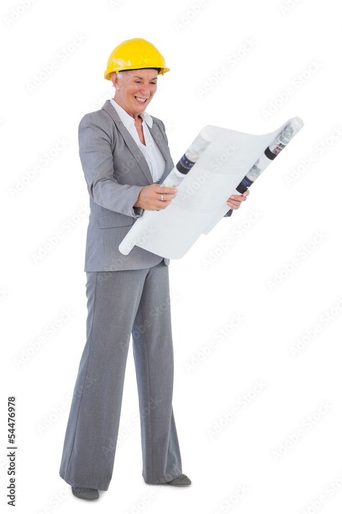 Architect wearing hardhat and looking at plan Architect wearing hardhat and looking at plan