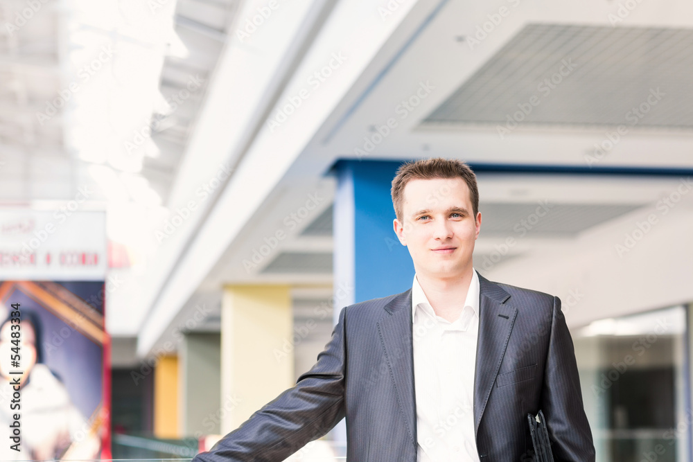 Handsome young businessman in a shopping center Handsome young businessman in a shopping center