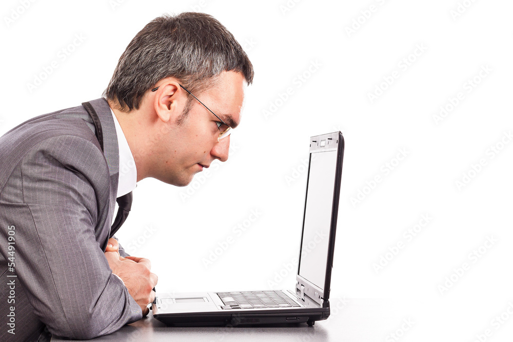 Concentrated businessman sitting at office desk working with lap Concentrated businessman sitting at office desk working with lap