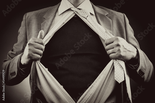 Conceptual image of a man tearing off his shirt