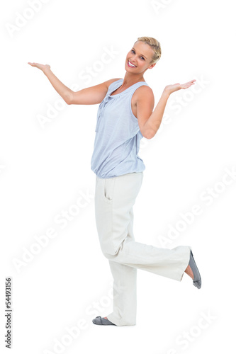 Happy woman standing with hands up and leg raised