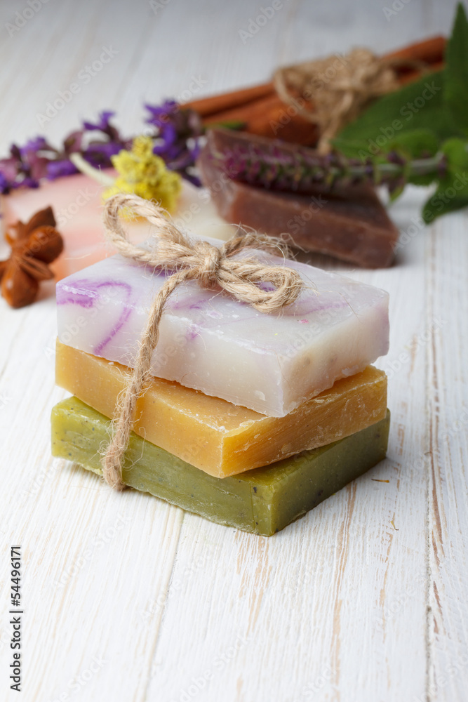Different natural homemade soap on wooden table with herbs Different natural homemade soap on wooden table with herbs