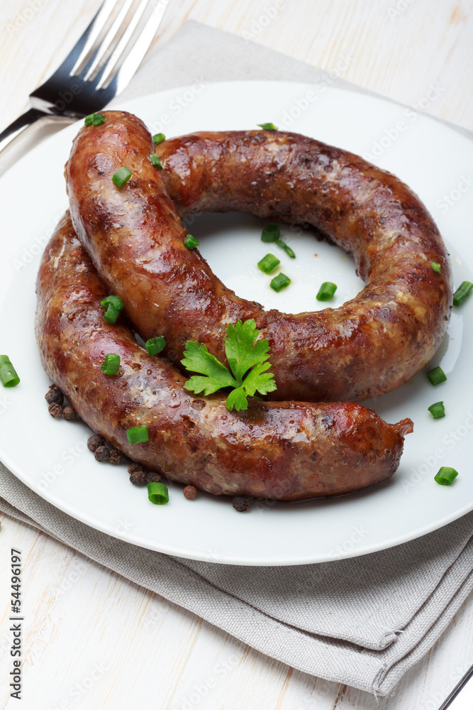 Traditional homemade coiled sausage on wooden table Traditional homemade coiled sausage on wooden table