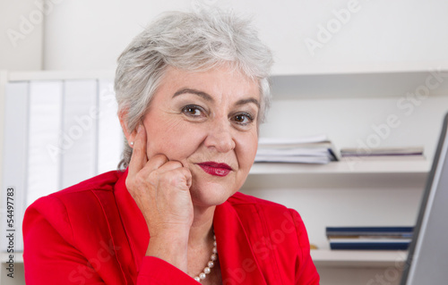 Gesicht einer grauhaarigen älteren Frau mit Falten im Büro photo