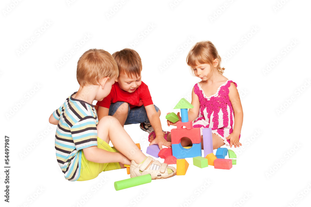 Three children playing and building together. Three children playing and building together.