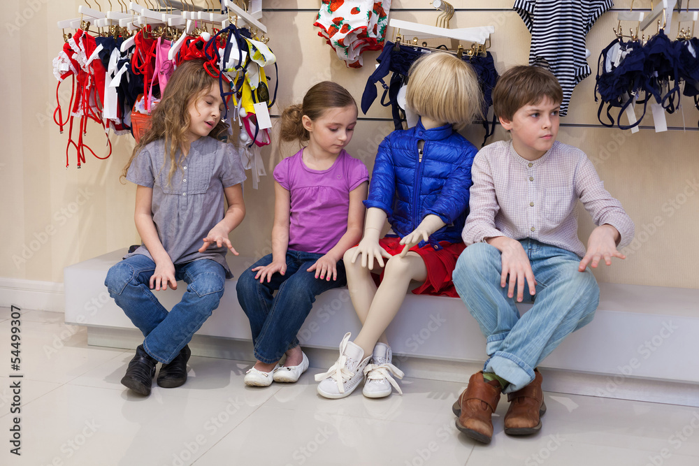 boy and girls sitting together with mannequins