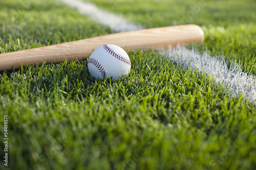 Baseball bat and ball on grass near field stripe