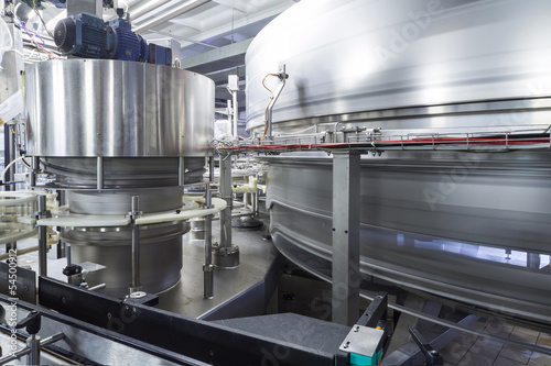 Large shiny tanks and tubing in brewery
