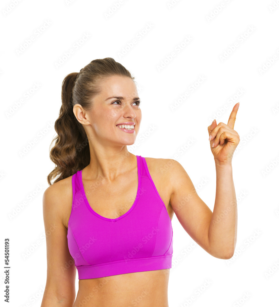 Smiling healthy young woman pointing on copy space Smiling healthy young woman pointing on copy space
