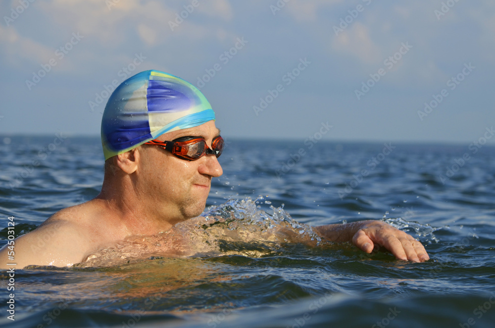 Мужчина плавает.