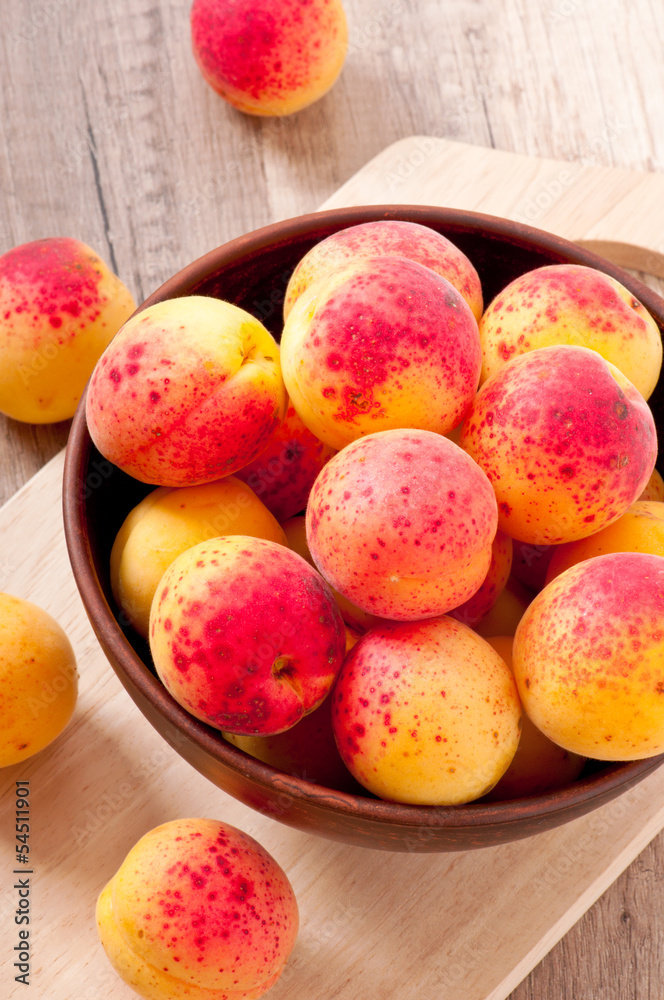 bowl of fresh apricots on wooden table bowl of fresh apricots on wooden table