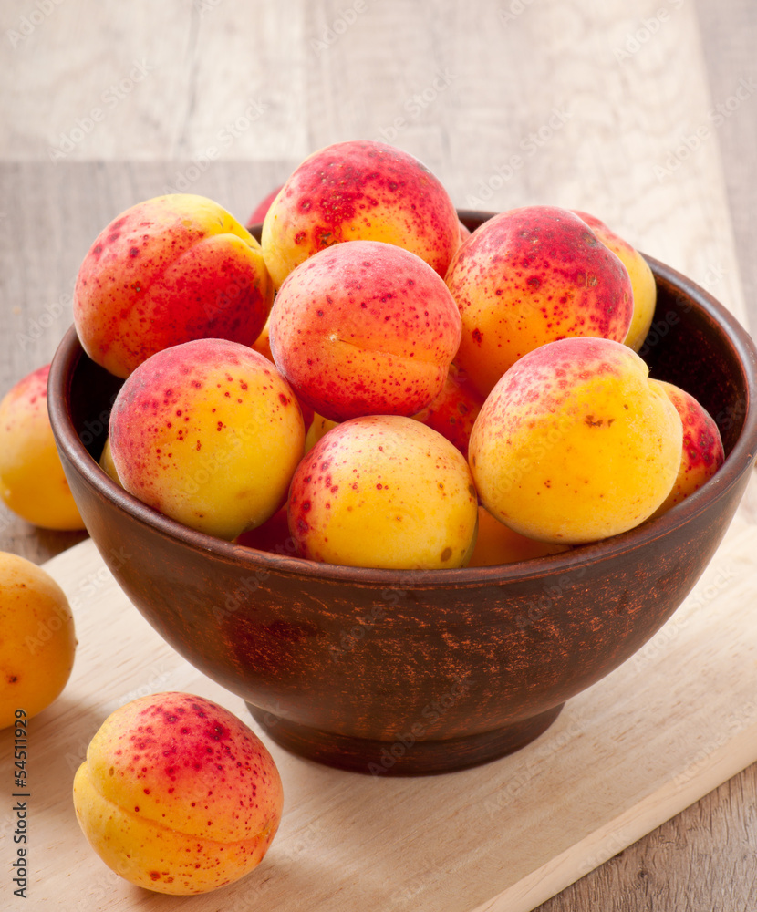 bowl of fresh apricots on wooden table bowl of fresh apricots on wooden table