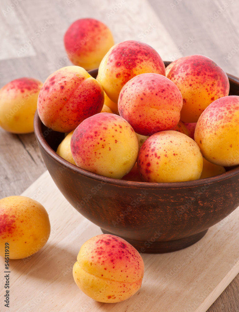 bowl of fresh apricots on wooden table bowl of fresh apricots on wooden table