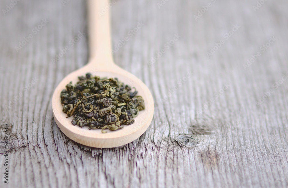 Spoon of green Tea leaves on wooden background Spoon of green Tea leaves on wooden background